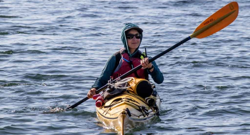 a student paddles a yellow kayak on an outward bound expedition 